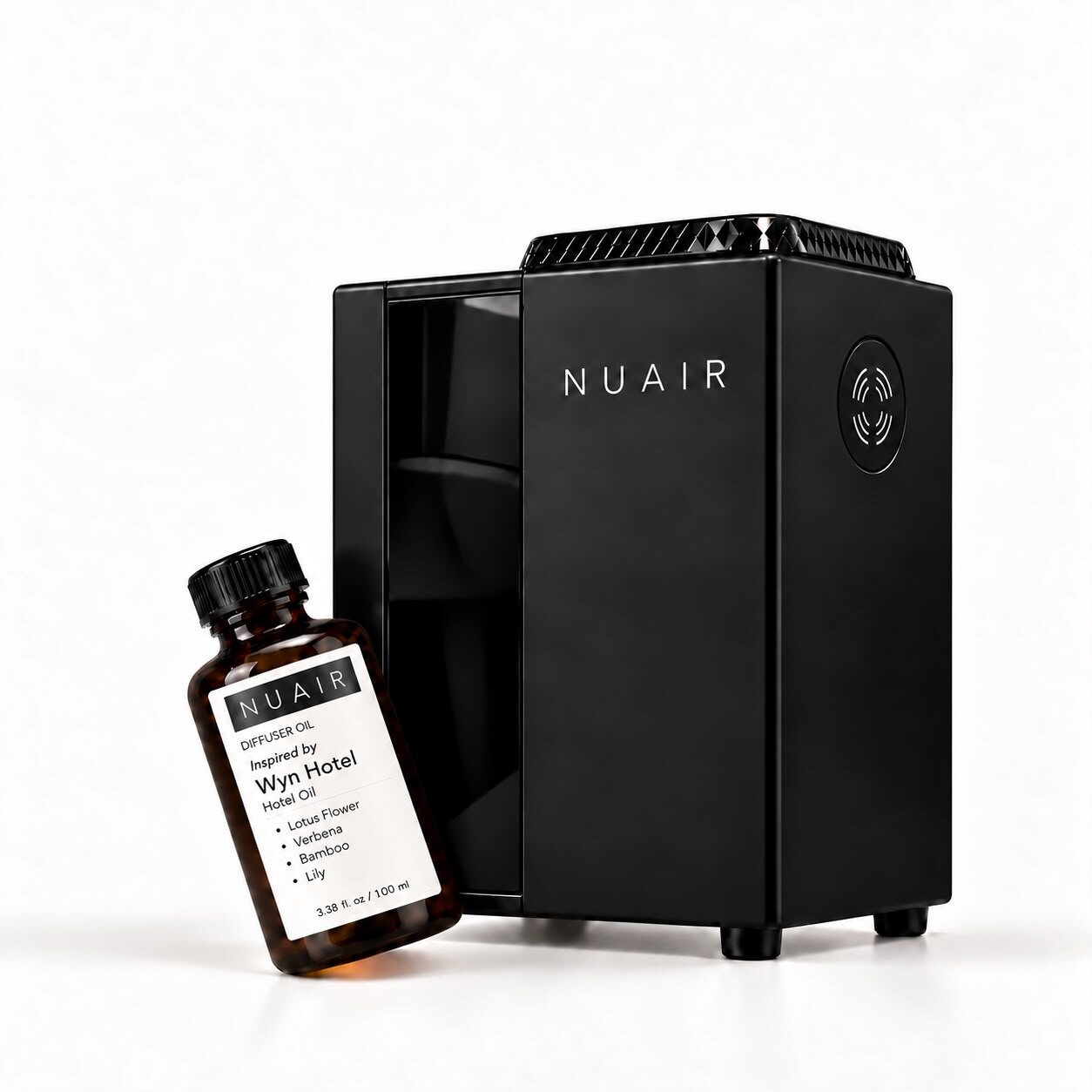 A NUAIR diffuser oil bottle beside the Studio 1 waterless electric diffuser