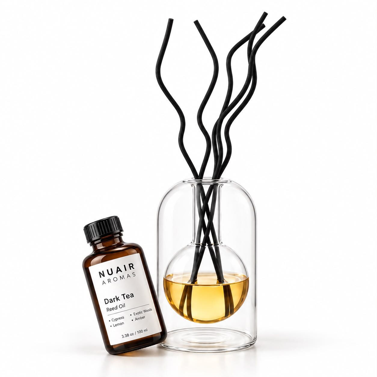 A NUAIR reed oil bottle beside the Glass Reed diffuser with black reeds